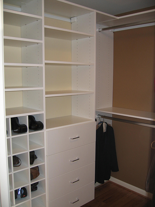 Closet with white painted custom shelving and drawers