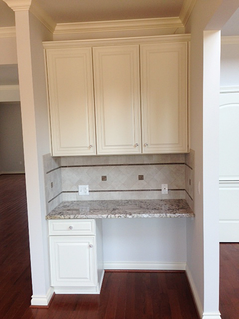 Desk area adjacent to kitchen with matching cabinetry