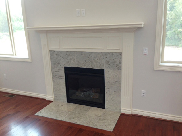 Fireplace surrounding by granite tile and painted mantle above