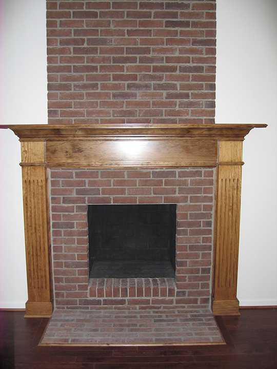 Fireplace with brick landing and wooden mantle