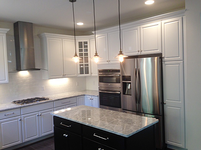 Kitchen featuring island with contrasting cabinet color