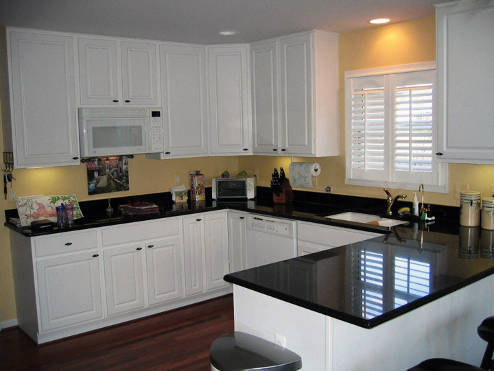 Kitchen with white painted cabinet and dark quartz countertops