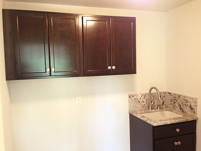 Laundry room with dark cabinetry