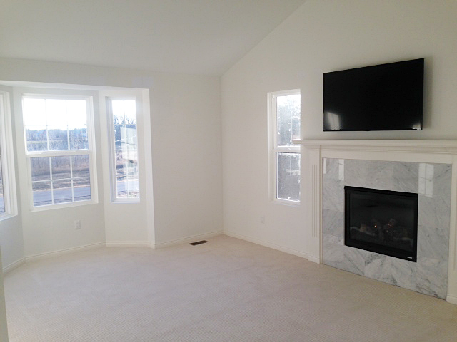Master bedroom with tile surrounded fireplace and tv over mantel