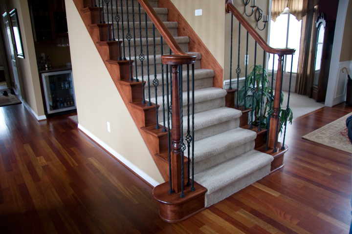 Staircase with maple railing and rod iron spindles with decorative baskets