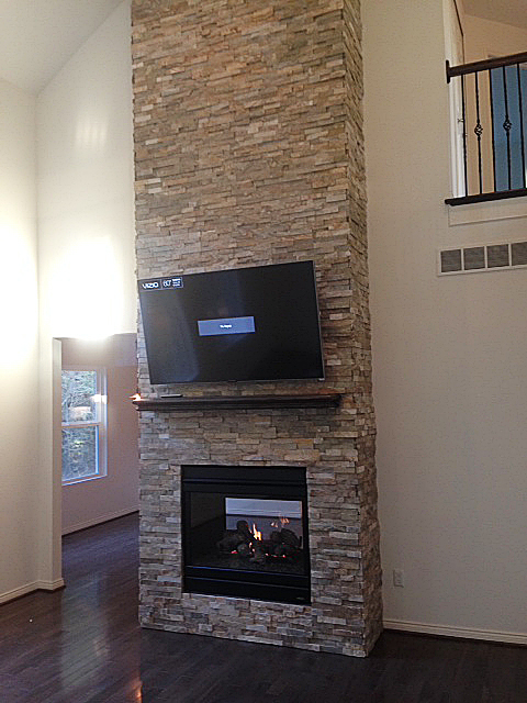 Two room fireplace with stacked ledge rock from floor to ceiling