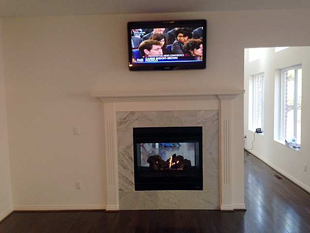 Two sided fireplace between kitchen and great room, encased in tile
