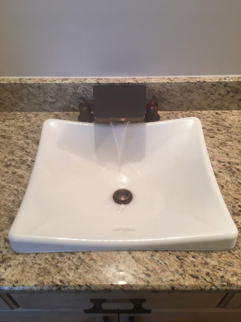 bathroom sink with a cascade faucet into ceramic sink