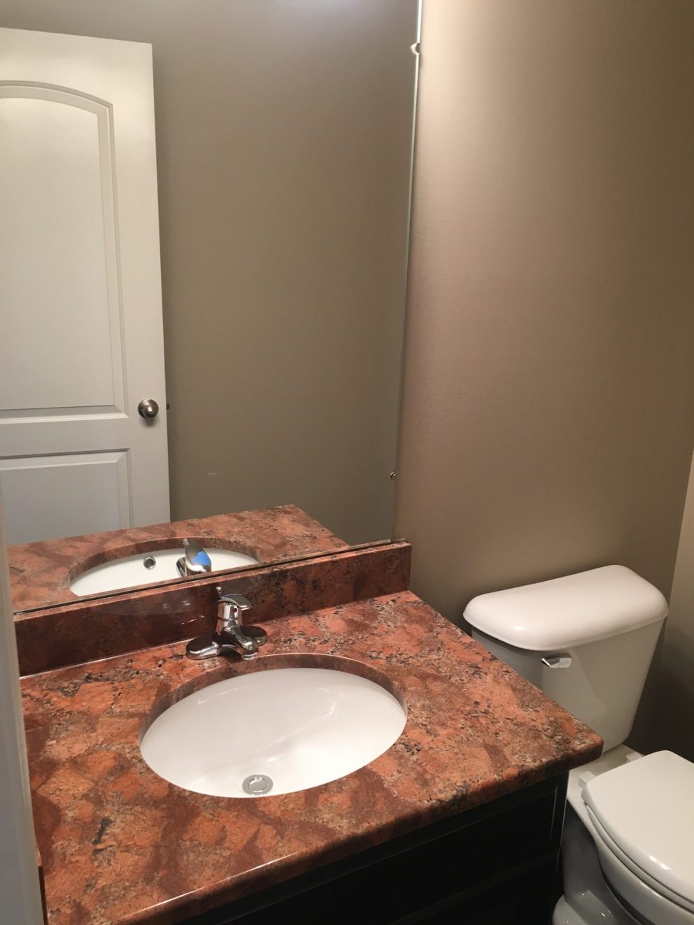 Bathroom with granite counter top and large mirror