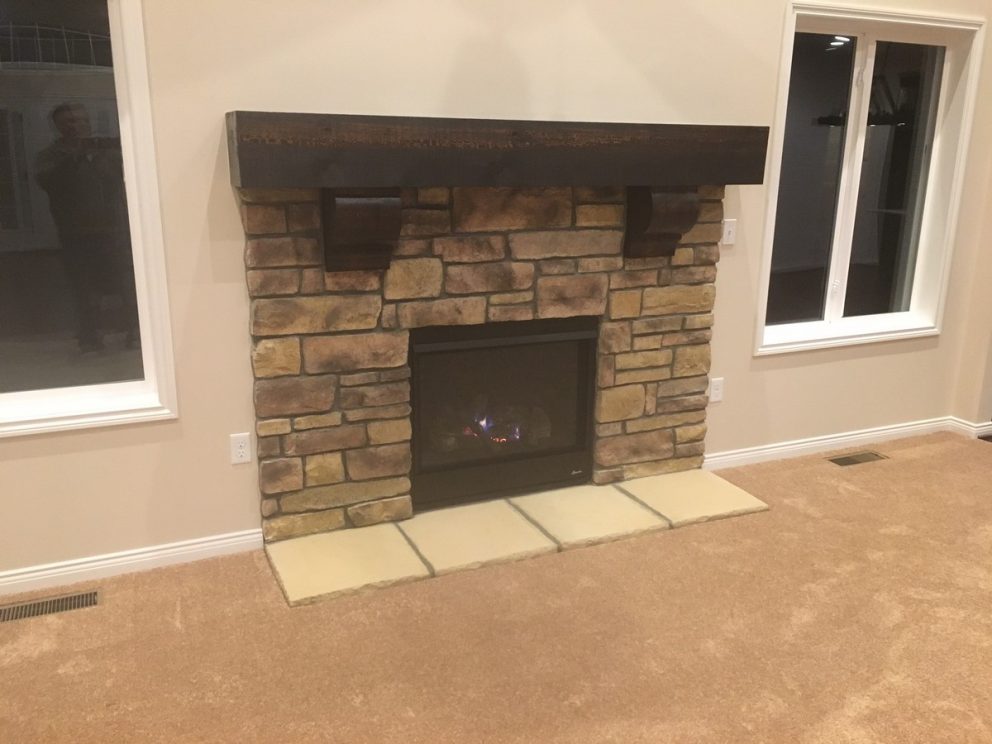 Fireplace surrounded in brick with tile footing and wooden mantel