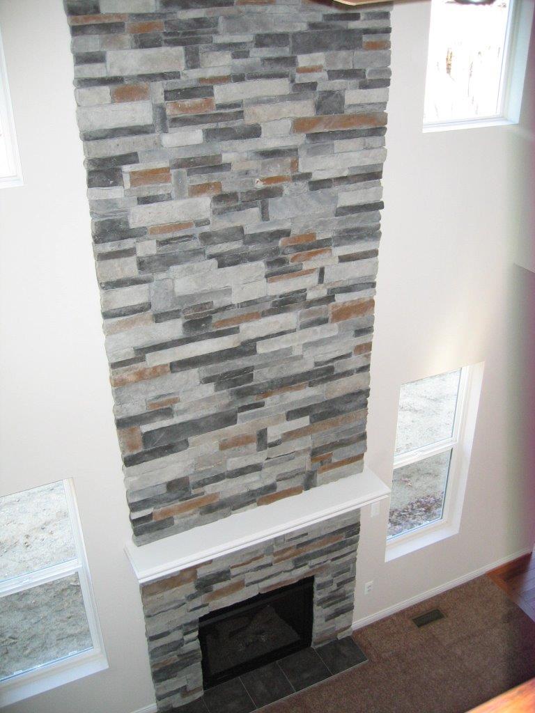 Fireplace surrounded with cut stone that continues to the ceiling