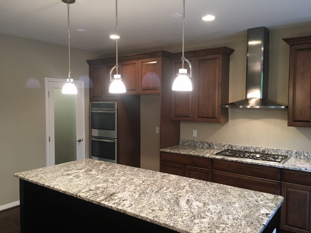 Kitchen lights hung over a granite counter top island