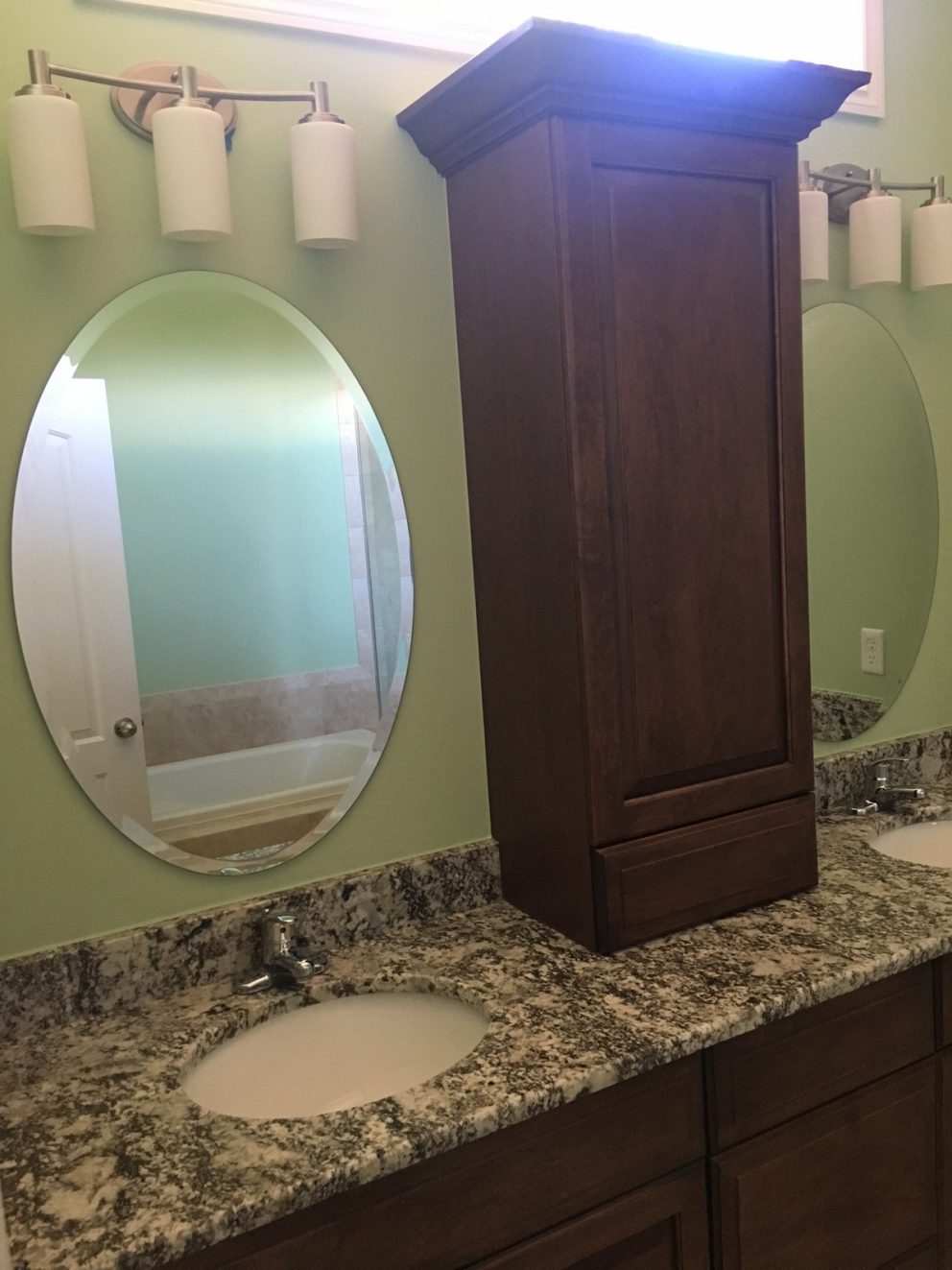 Master bath sinks with granite counter tops and a tower cabinet