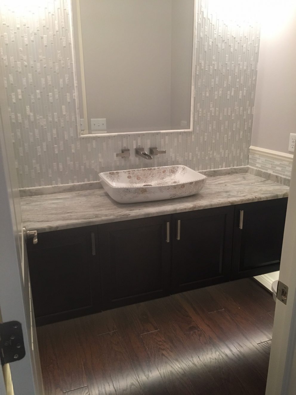 Powder room with floating vanity, mirror inlay and tile back wall