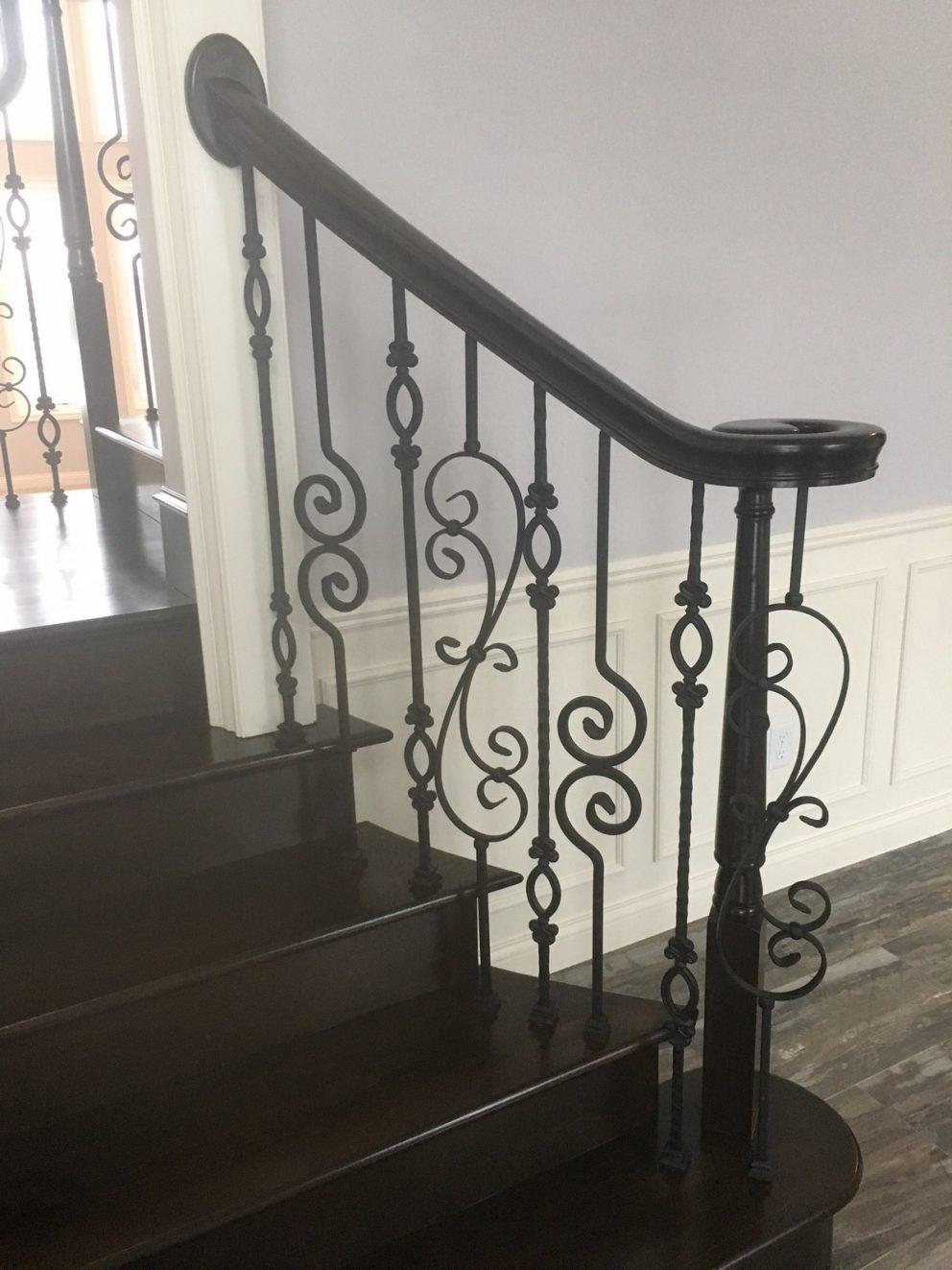 Staircase landing showing off the decorative rod iron spindles and full wood finish